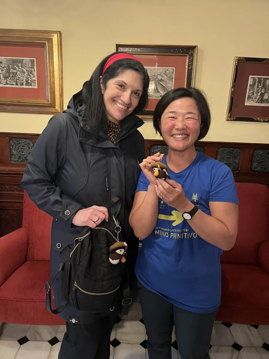 A customer holding a Tiny Pilgrim doll with its maker