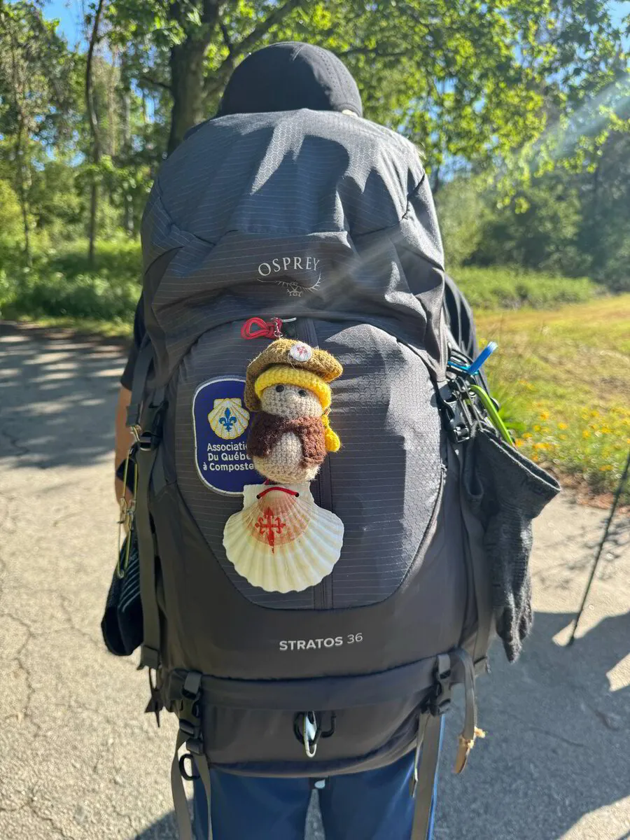 Tiny Pilgrim companion doll attached to a pilgrim's backpack
